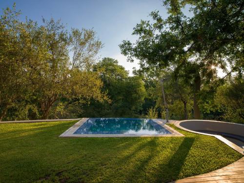 a swimming pool in the middle of a lawn at Oase by 7 Star Lodges - Greater Kruger Private 530ha Reserve in Hoedspruit