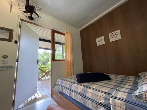 1 dormitorio con 1 cama y puerta a un balcón en CASA DE CHICO, en Guarda do Embaú