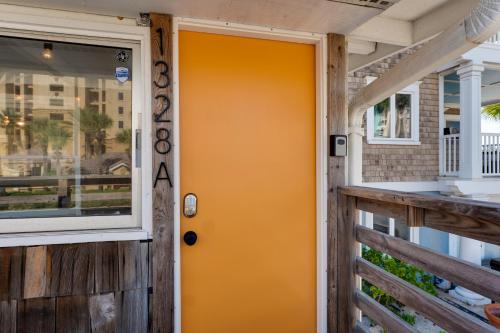 an orange door on a house with a porch at Be A Nomad Laid Back Beach Home in Jacksonville Beach