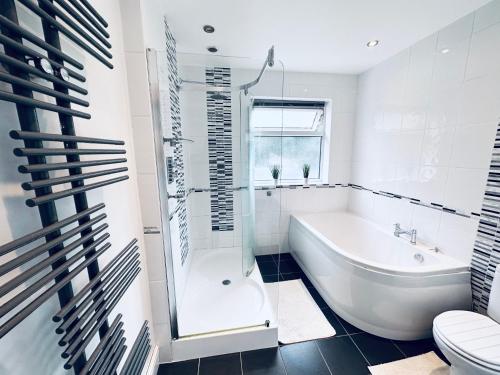 a bathroom with a tub and a toilet and a sink at Impeccable 3-Bed House in Nottingham Central in Nottingham