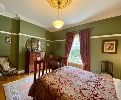 a bedroom with a bed and a window and a chandelier at Warburton House in Warburton