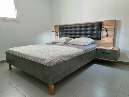 a bedroom with a large bed with a headboard at Appartement Pyé koko in Lamentin