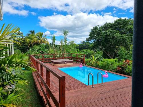 a wooden deck with a swimming pool on top of it at Appartement Pyé koko in Lamentin