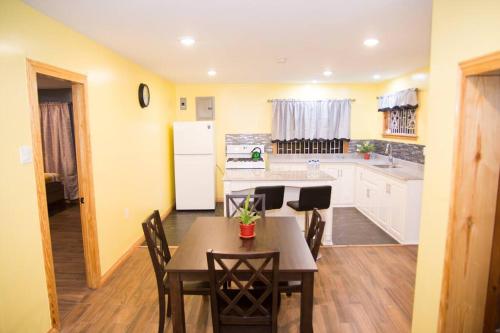 a kitchen with a table and chairs and a refrigerator at Avalon Regia 2 Bathroom Downstairs Apartment in Georgetown