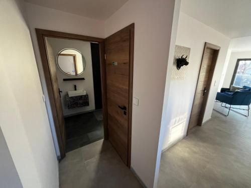 a hallway with a wooden door and a mirror at Près Colmar 6 bis in Wolfgantzen