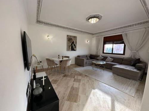 un soggiorno con divano e tavolo di Luxury, Cosy Apartement (Wifi, Balcony, Parking) a Marrakech