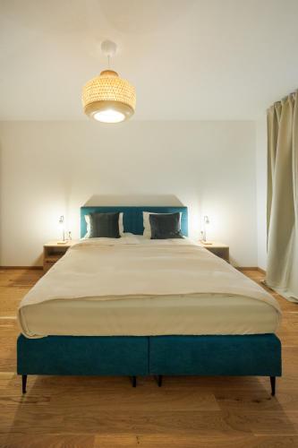 a bedroom with a large bed with a blue headboard at Zoder Apartments in Vienna