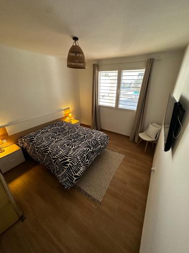 a bedroom with a black and white bed and a window at Vivienda La Colina in Córdoba