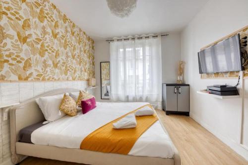 a bedroom with a large bed and a television at Studio cosy en centre-ville Proche de Paris in Pierrefitte-sur-Seine