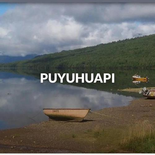 um barco sentado na margem de um lago em cabañas mateo 01 em Puyuhuapi