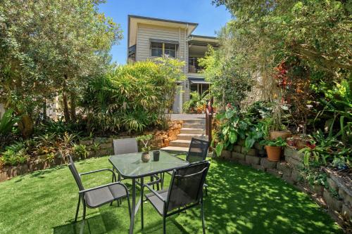 a garden with a table and chairs on the grass at The Guesthouse Maleny in Maleny