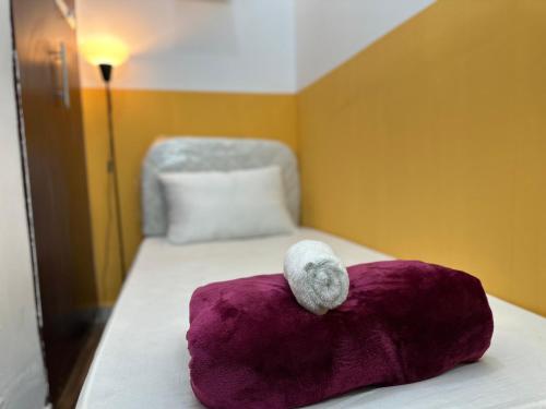 un animal de peluche sentado encima de una almohada morada en una cama en Wonderful Partition Room in Al Barsha 1 Near Metro en Dubái