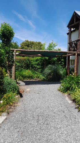 a stone walkway with a pavilion in a garden at Departamentos Serranos en Tandil in Tandil