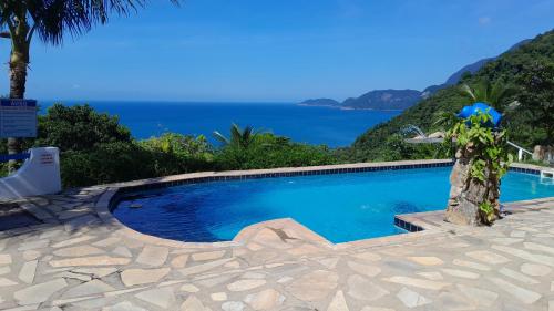 a swimming pool with a view of the ocean at Vila Lia in São Sebastião