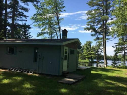 a small green building in a yard with trees at Sandy Hollow Vacation Home in White