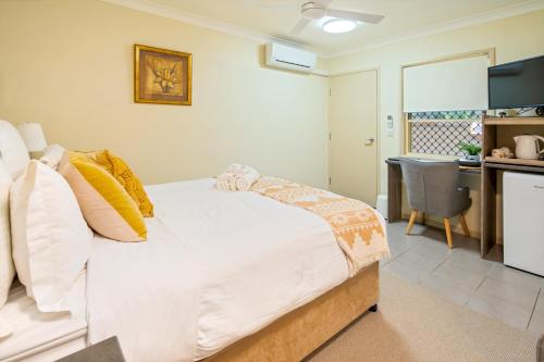 a bedroom with a large bed and a kitchen at The Guesthouse Maleny in Maleny