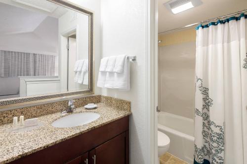 a bathroom with a sink and a toilet and a mirror at Residence Inn Anaheim Placentia/Fullerton in Placentia