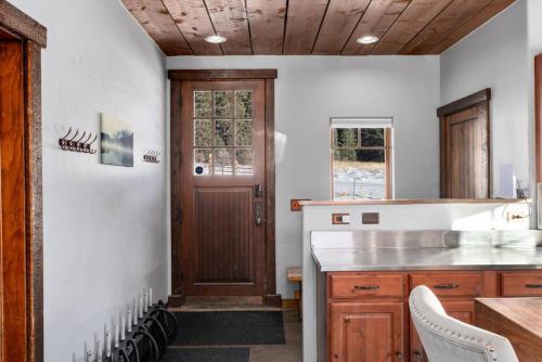 a kitchen with white walls and a wooden door at The Bross Ranch Cabin - Open Floor Plan! 10Mi to Ski Breck! Hot Tub! in Fairplay