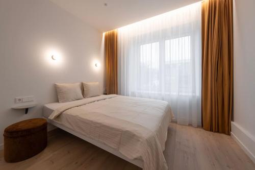 - une chambre avec un lit et une grande fenêtre dans l'établissement Downtown getaway apartments by Prime Rentals IV, à Kaunas