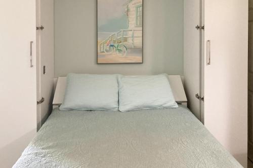 a bed in a room with a picture on the wall at Ocean’s Treasures Retreat Beach Condo in Ponte Vedra Beach