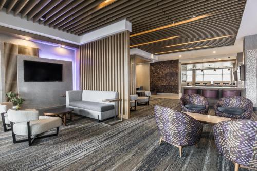 a lobby with chairs and tables and a waiting room at Holiday Inn Express & Suites - Toronto Airport South, an IHG Hotel in Toronto