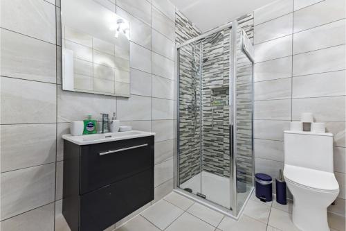a bathroom with a shower and a toilet at Stylish and Family Friendly 3 Bedroom Apartment in London