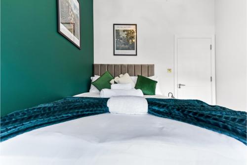 a bedroom with a large bed with green walls at Stylish and Family Friendly 3 Bedroom Apartment in London
