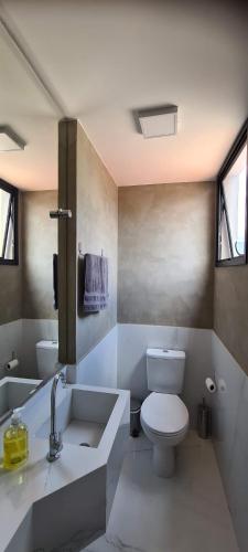 uma casa de banho branca com um WC e um lavatório em Linda cobertura na Savassi em Belo Horizonte