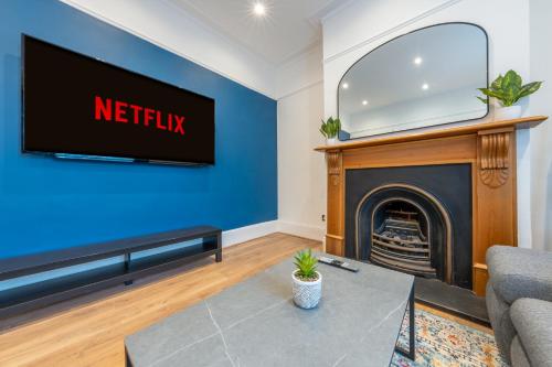 a living room with a tv and a fireplace at West London Period House in London