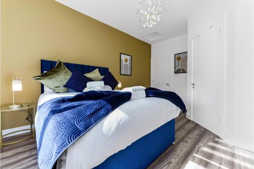 a bedroom with a bed with blue and white sheets at Lovely Two Bedroom with Ensuite Bathrooms in London