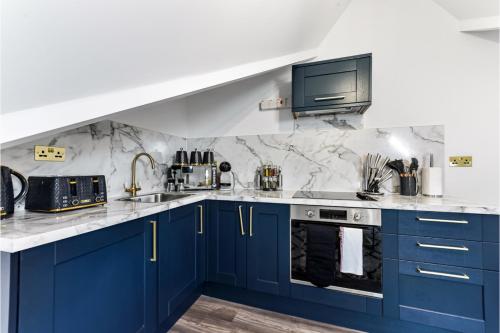 a kitchen with blue cabinets and a sink at Lovely Two Bedroom with Ensuite Bathrooms in London