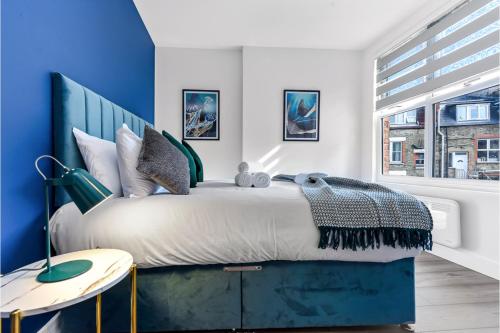 a bedroom with a large bed with blue walls at Lovely Two Bedroom with Ensuite Bathrooms in London