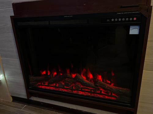 a fireplace with red flames in a room at Villazul 1 in Poás