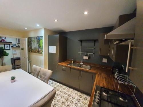 a kitchen with a sink and a counter top at Wallwood Rooms in London