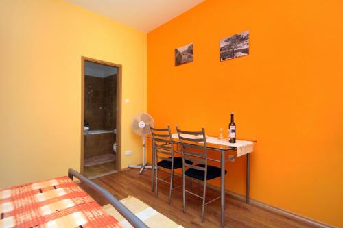 a orange room with a table and two chairs at Apartments with a parking space Vrisnik, Hvar - 8733 in Jelsa