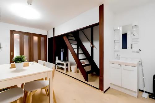 a kitchen and dining room with a table and a staircase at Yagara Terrace House B in Osaka