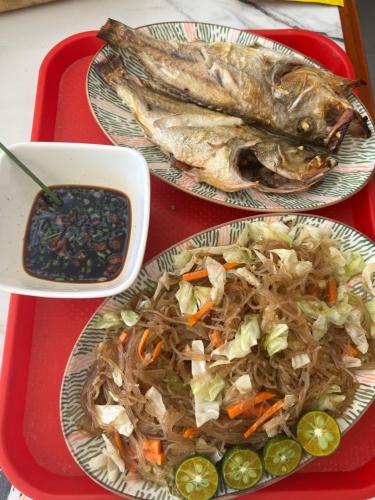 two plates of food on a red tray with fish at JCAH BEACH HOUSE free WiFi in Araceli