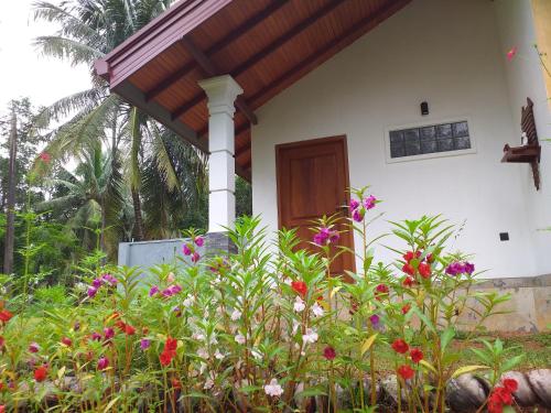 a house with a porch with flowers in front of it at Bel vedere in Minuwangoda