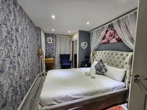 a bedroom with a white bed with a canopy at Wallwood Rooms in London