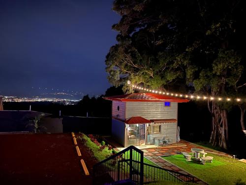 a small house with lights on the roof at night at Villazul 1 in Poás