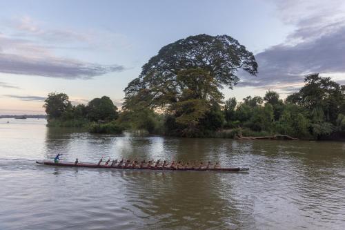 a group of people in a boat on a river at BABA Guesthouse in Don Det