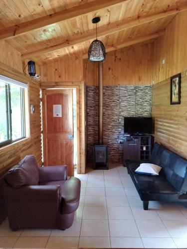 a living room with a couch and a fireplace at Cabaña Don Tito en Buchupureo in Cobquecura