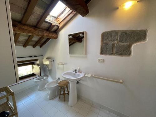 a bathroom with a sink and a toilet and a window at Spacious Holiday Home in Amandola with Swimming Pool in Amandola