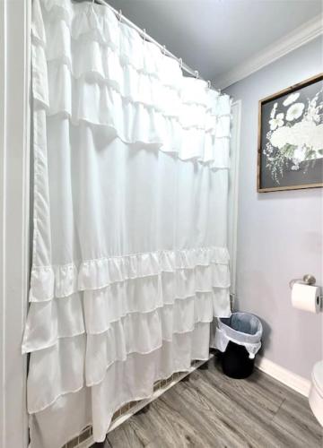 a bathroom with a white shower curtain and a toilet at Dock House, Close to Camp Lejeune, water access, DOCK, king bed in Cedar Point