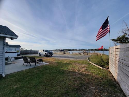 an american flag flying in the yard of a house at Dock House, Close to Camp Lejeune, water access, DOCK, king bed in Cedar Point