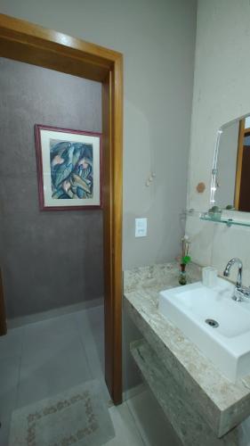 a bathroom with a sink and a mirror and a shower at Cantinho da paz in Caraguatatuba