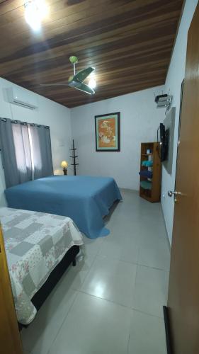 a bedroom with a blue bed and a ceiling at Cantinho da paz in Caraguatatuba