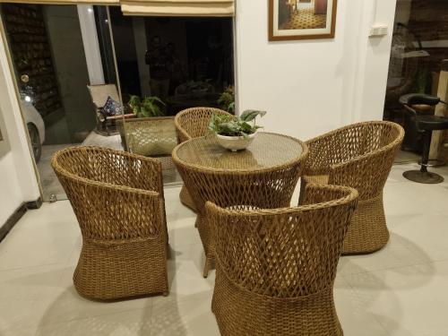 a group of wicker chairs and a table with a plant at River Front Villa in Wadduwa