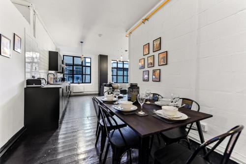 a dining room with a table and chairs and a kitchen at Trendy and Eccentric Flat in Hackney in London