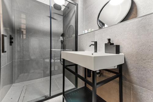 a bathroom with a sink and a shower at Trendy and Eccentric Flat in Hackney in London